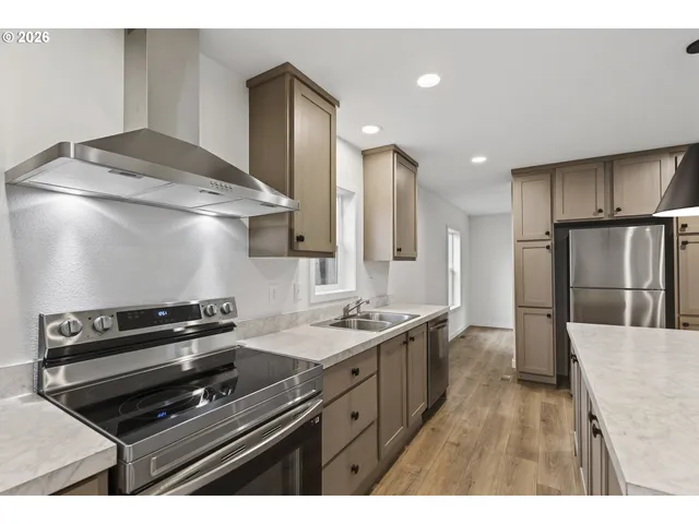 a kitchen with stainless steel appliances a sink stove and refrigerator