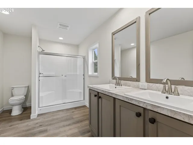 a bathroom with a granite countertop sink toilet a mirror and shower