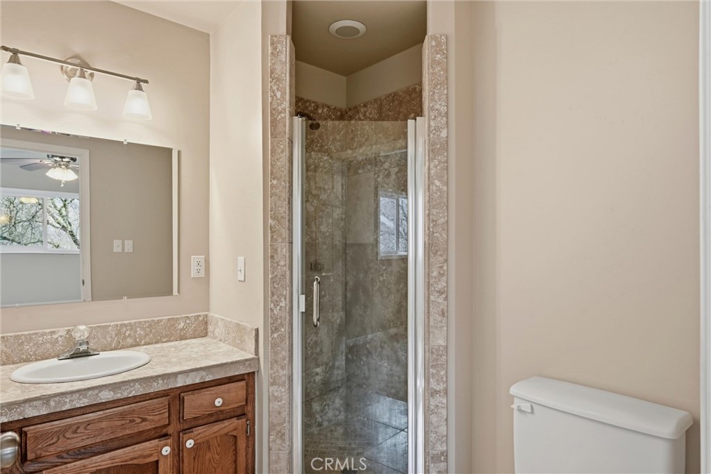 19474 Donkey Hill Road Hidden Valley Lake, CA 95467 - Photo 19 of 38 a bathroom with a granite countertop sink toilet and shower