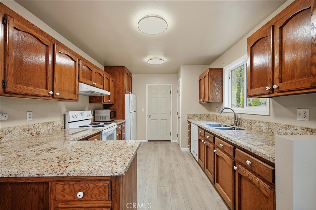 19474 Donkey Hill Road Hidden Valley Lake, CA 95467 - Photo 4 of 38 a kitchen with stainless steel appliances granite countertop a sink stove microwave and cabinets
