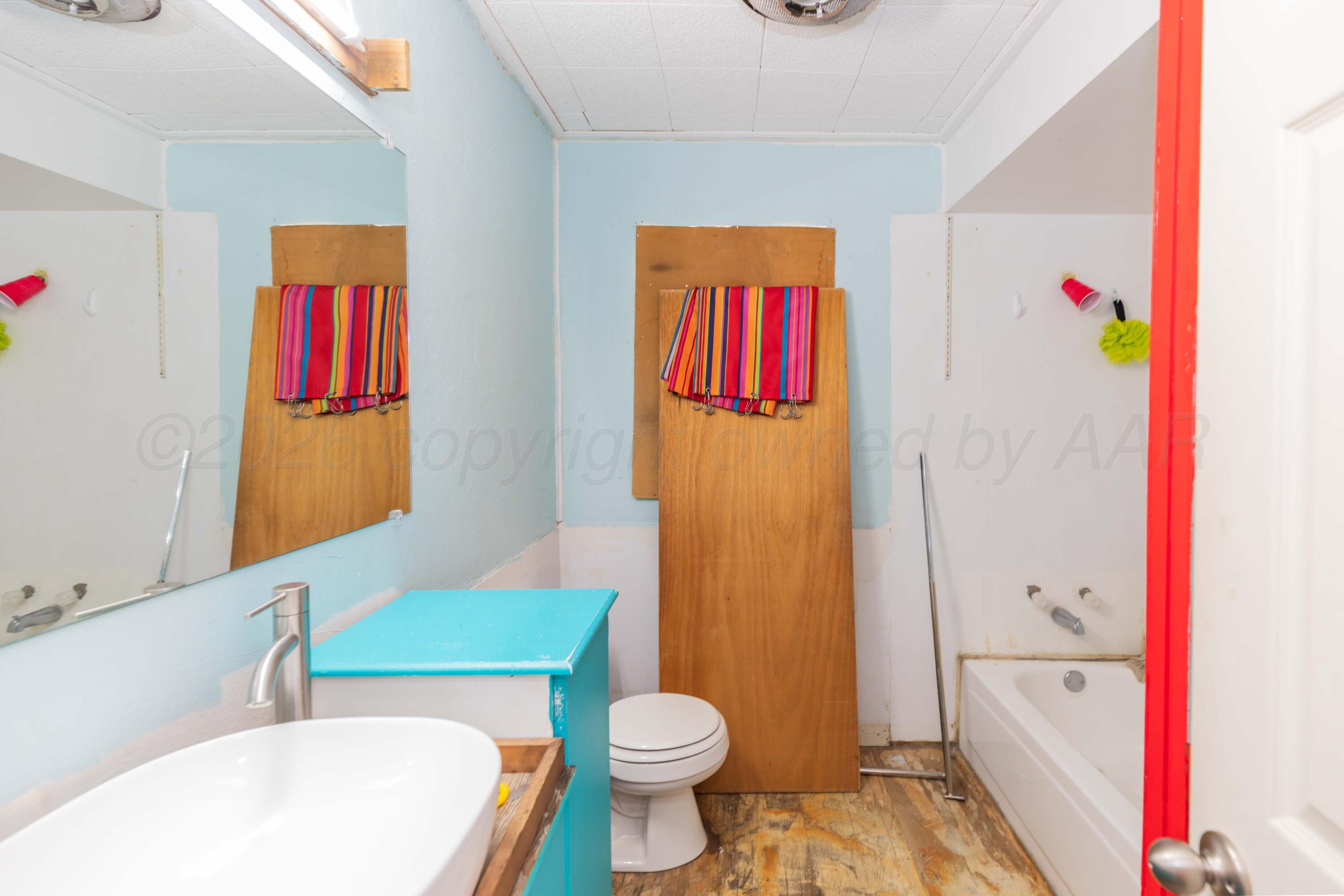 107 Inverness Street Borger, TX 79007 - Photo 12 of 22 a bathroom with a bath tub and a toilet