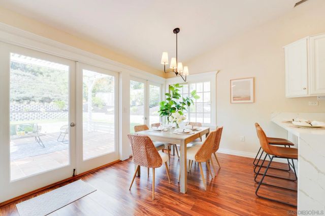 a kitchen with stainless steel appliances kitchen island granite countertop a white table and chairs in it
