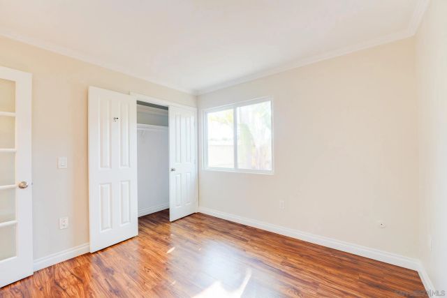 a bedroom with a bed and a wooden floor