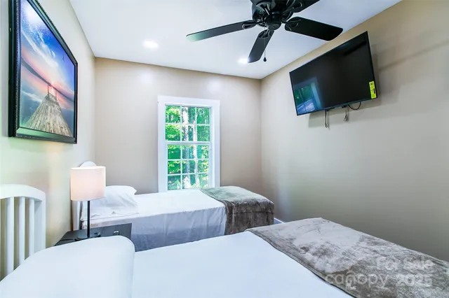 a bedroom with two beds and a flat screen tv