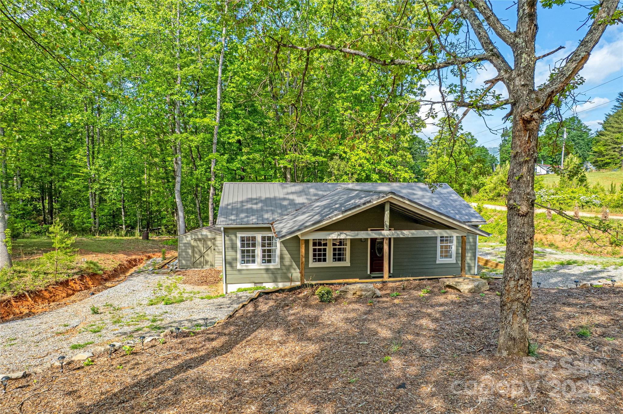 115 Cold Springs Drive Mill Spring, NC 28756 - Photo 2 of 42 a house with trees in the background