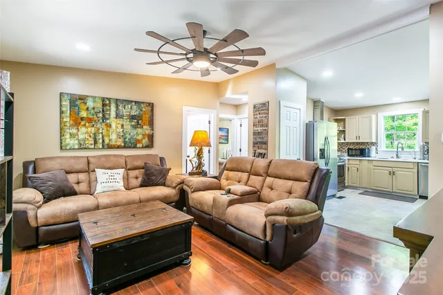 a living room with furniture kitchen and a chandelier