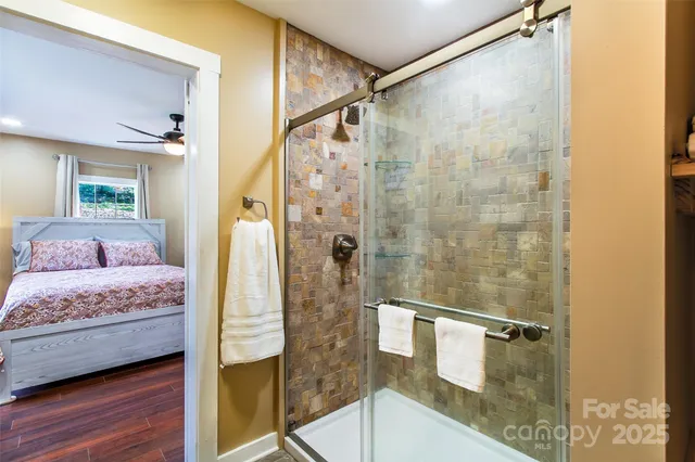 a en suite bathroom with a granite countertop shower a sink and a mirror
