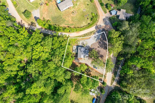 an aerial view of a residential houses with yard