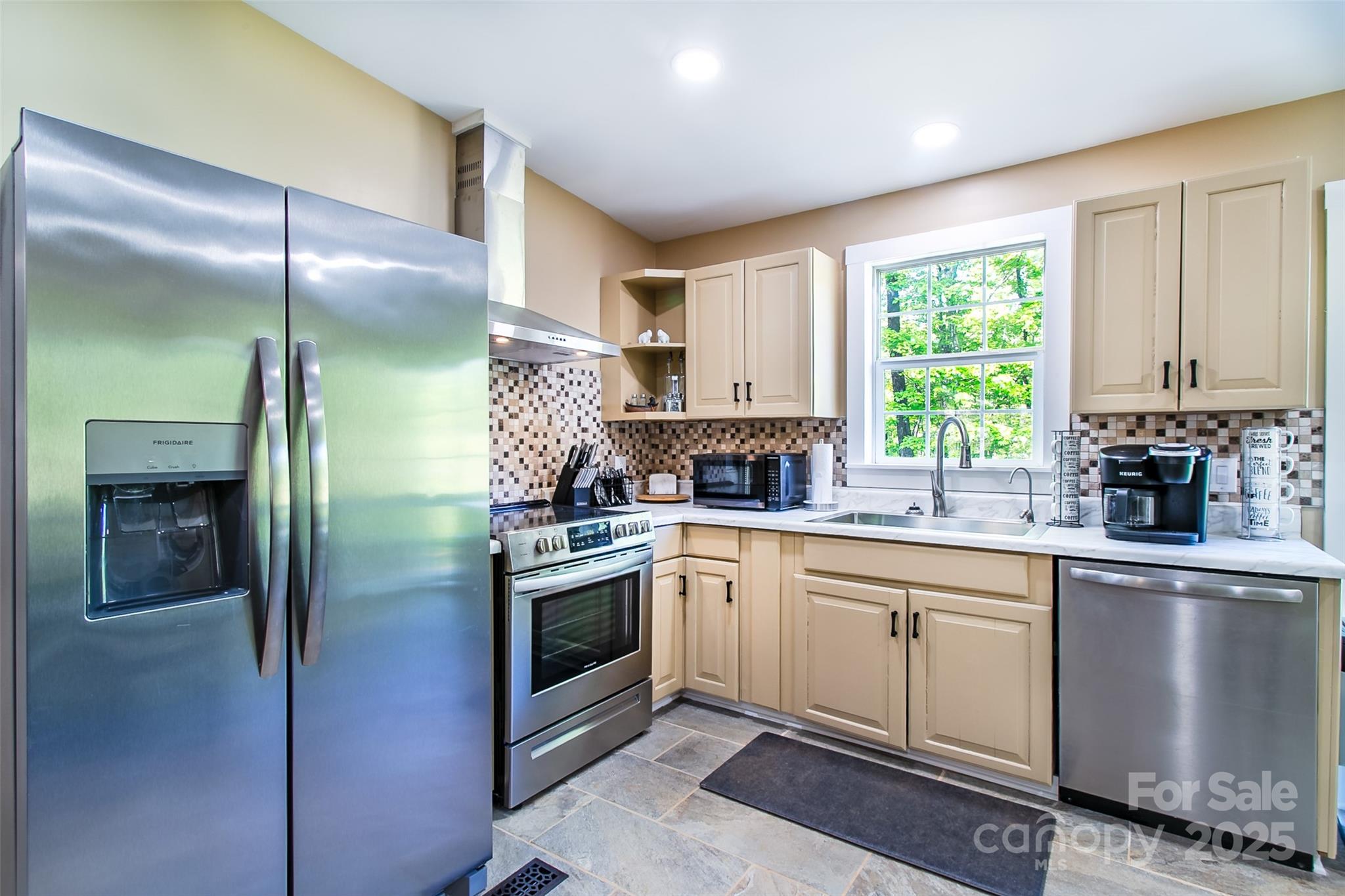 115 Cold Springs Drive Mill Spring, NC 28756 - Photo 8 of 42 a kitchen with stainless steel appliances granite countertop a refrigerator a sink a stove and white cabinets with wooden floor
