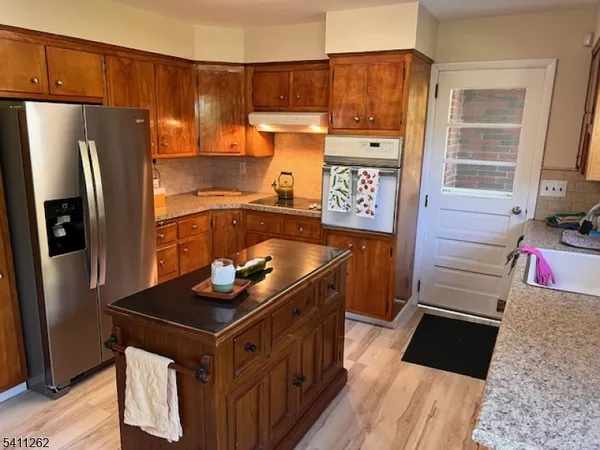 a kitchen with stainless steel appliances granite countertop a refrigerator stove and sink