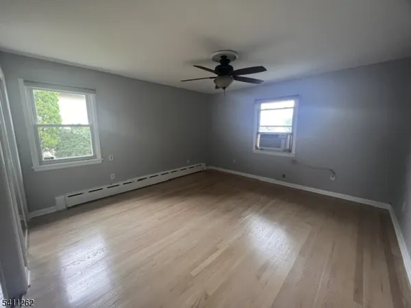 an empty room with a window and a ceiling fan