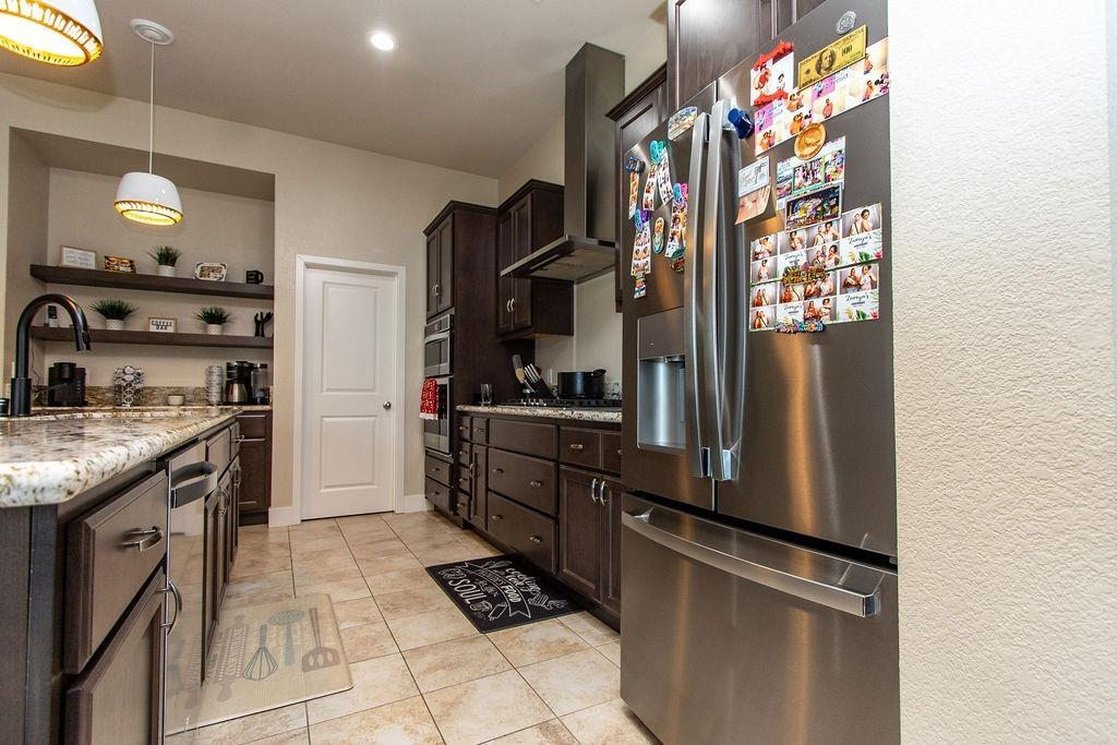 2354 Ruthie Place Manteca, CA 95337 - Photo 4 of 22 a kitchen with stainless steel appliances granite countertop a refrigerator and a stove