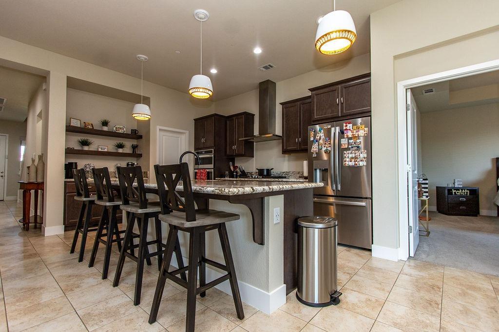2354 Ruthie Place Manteca, CA 95337 - Photo 5 of 22 a kitchen with stainless steel appliances granite countertop a refrigerator and a stove top oven