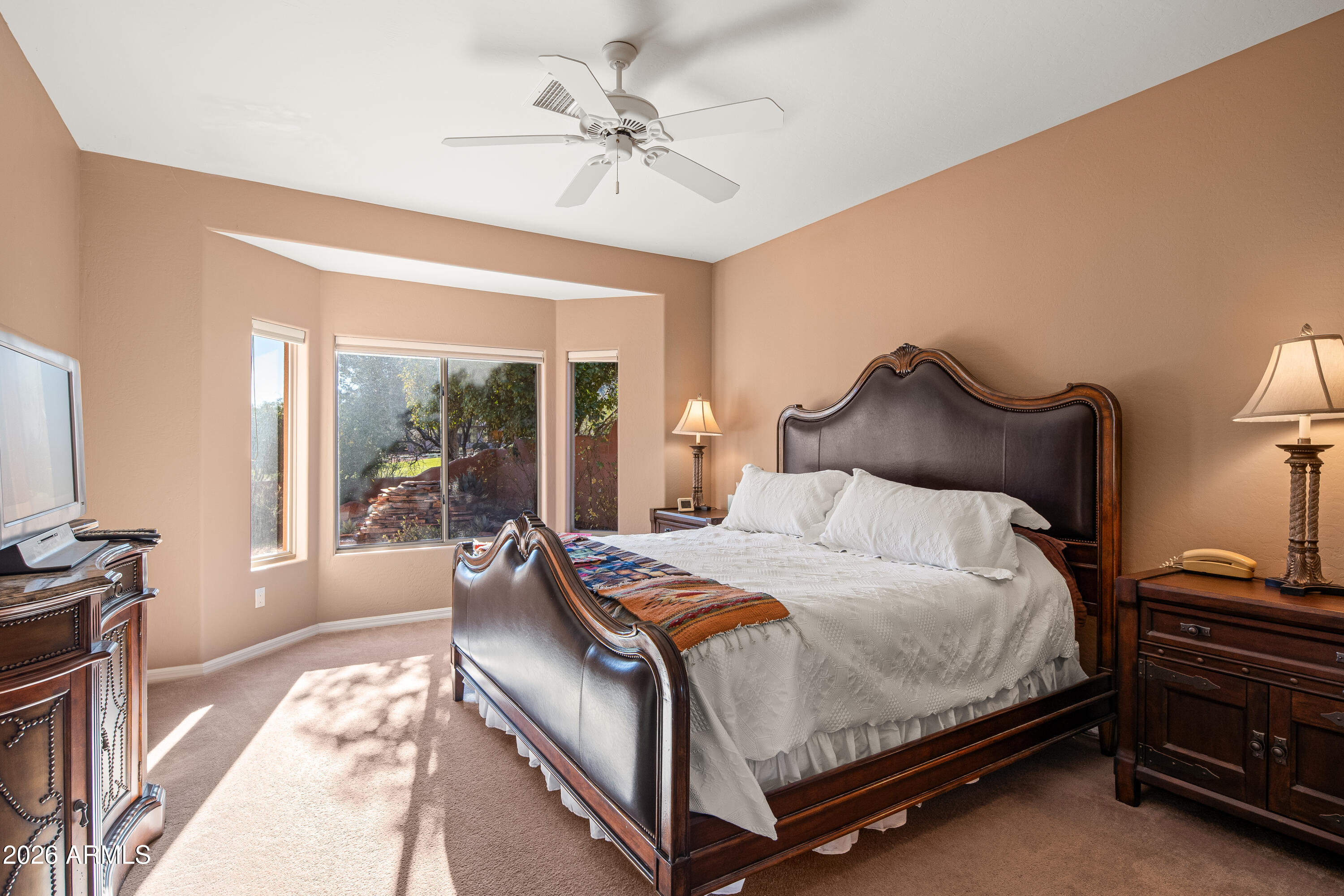 1070 Crown Ridge Road Sedona, AZ 86351 - Photo 12 of 28 a bedroom with a bed and a chandelier