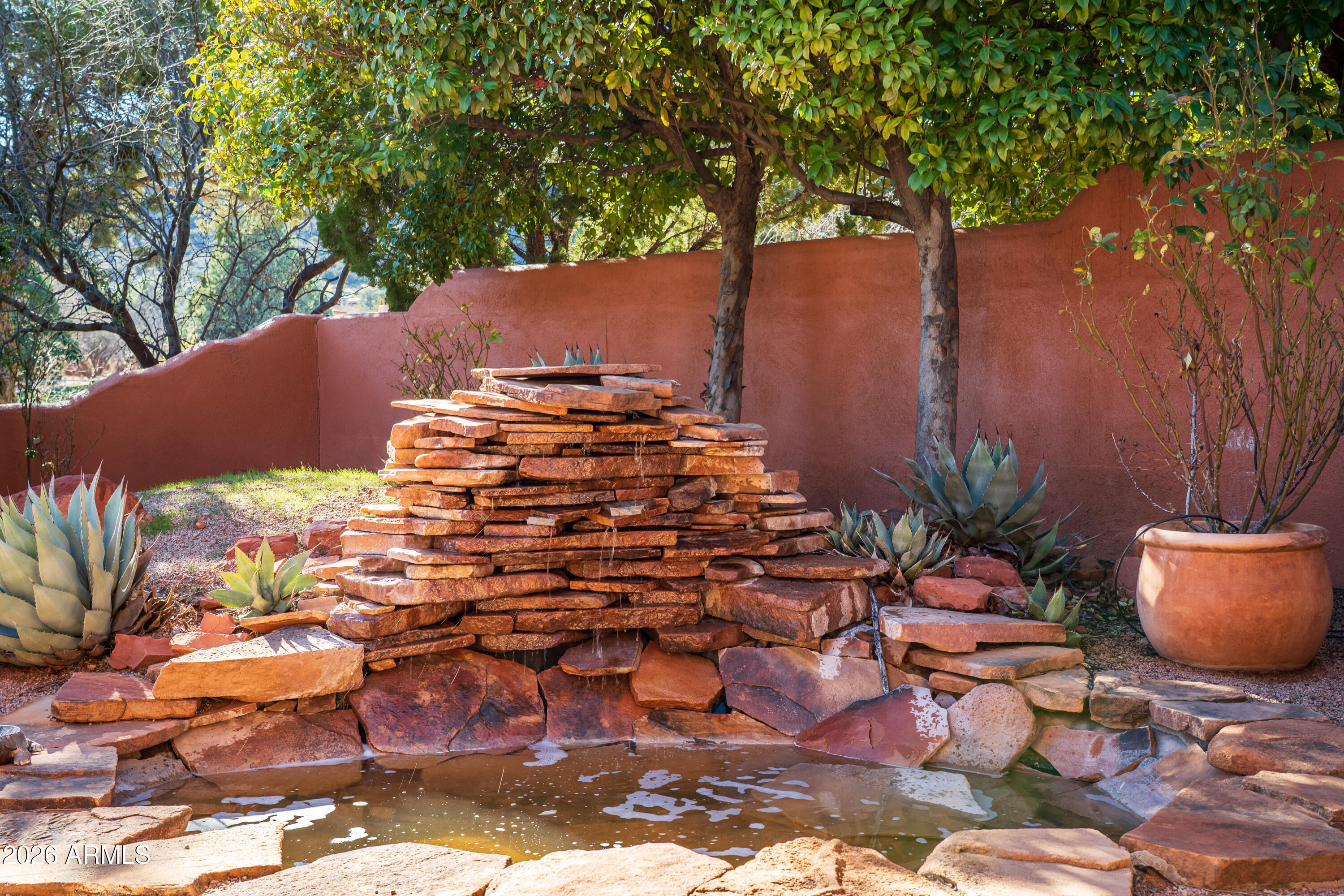 1070 Crown Ridge Road Sedona, AZ 86351 - Photo 27 of 28 a view of a patio with table and chairs potted plants and large tree