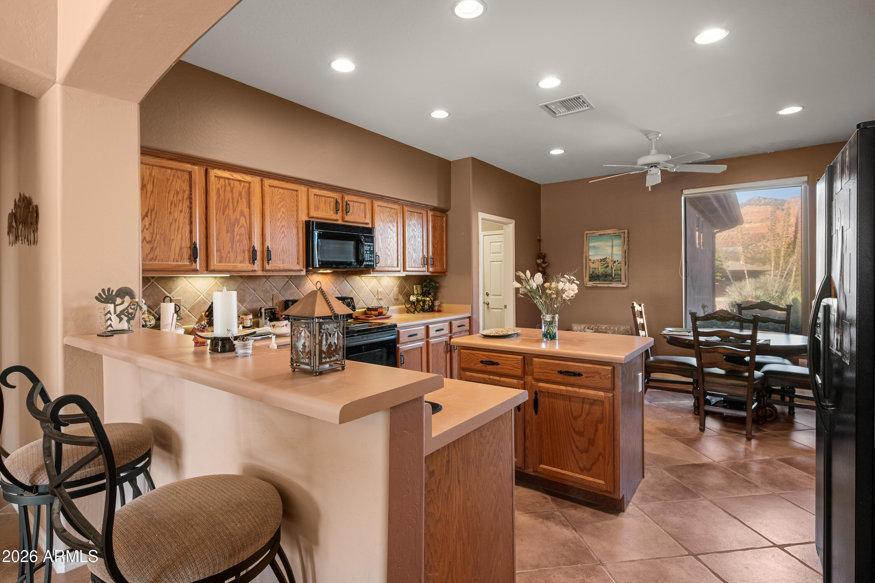 1070 Crown Ridge Road Sedona, AZ 86351 - Photo 9 of 28 a kitchen with a sink a stove and chairs