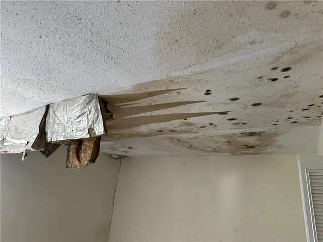 a room with water heater and wooden cabinet