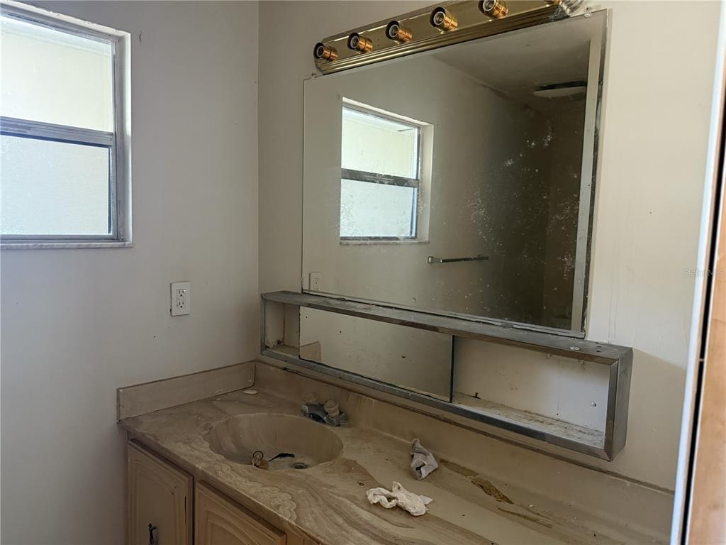 709 Southwest 75th Street, Unit 104 Gainesville, FL 32607 - Photo 33 of 34 a bathroom with a granite countertop sink window and mirror