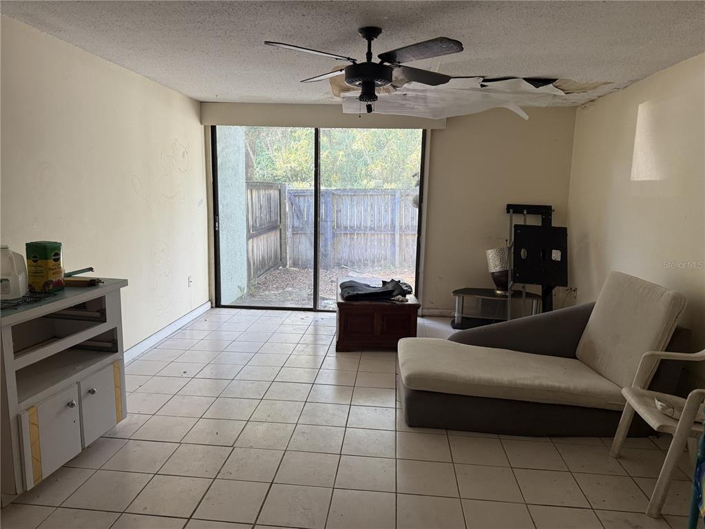 709 Southwest 75th Street, Unit 104 Gainesville, FL 32607 - Photo 10 of 34 a living room with furniture and a floor to ceiling window