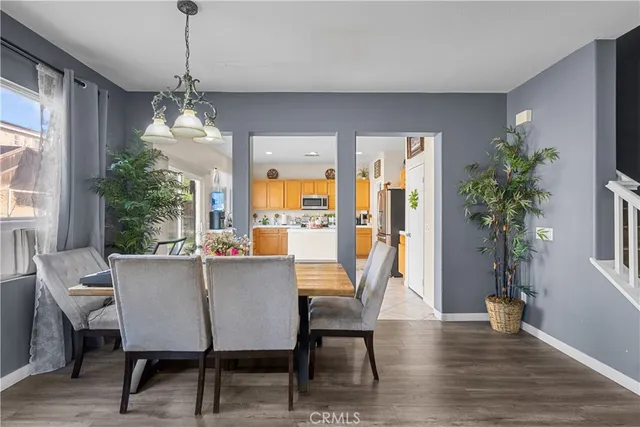 a dining room with furniture potted plants and wooden floor