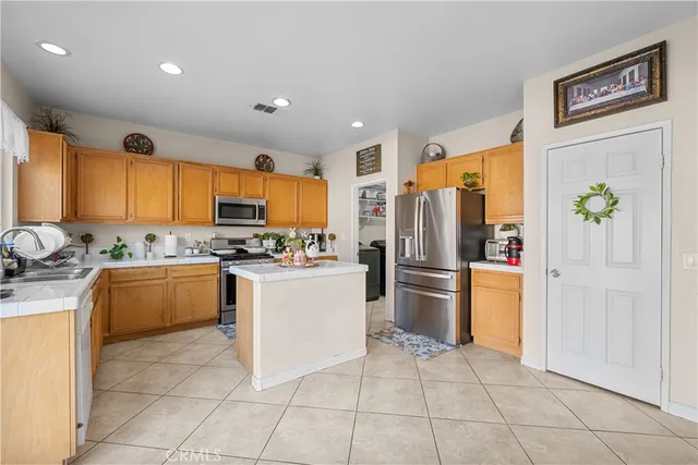 a kitchen with a refrigerator and countertop wooden cabinets