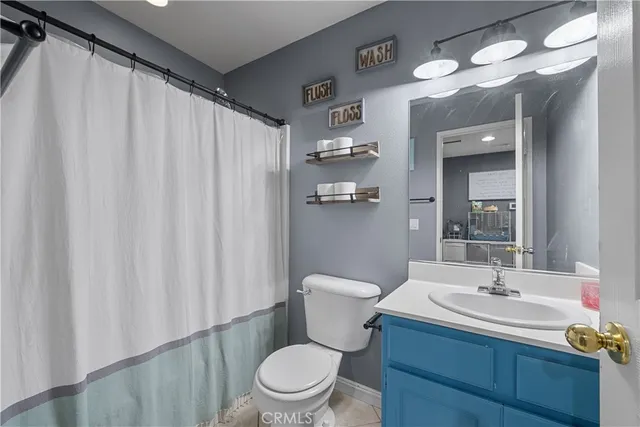 a bathroom with a sink a toilet and shower curtain