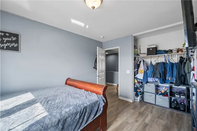 a bedroom with bed and wooden floor