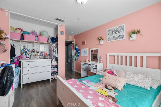 a bedroom with a bed a flat screen tv and a couch