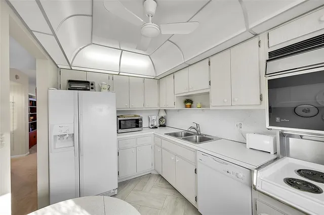 a kitchen with appliances a sink and cabinets