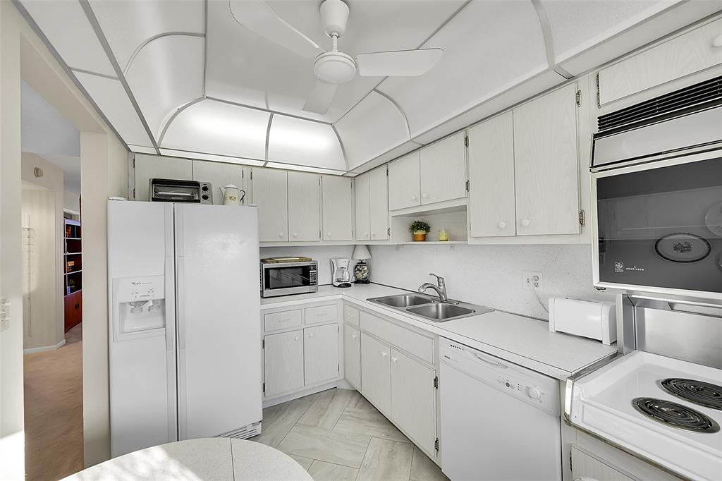 555 Northwest 4th Avenue, Unit 4190 Boca Raton, FL 33432 - Photo 6 of 18 a kitchen with appliances a sink and cabinets