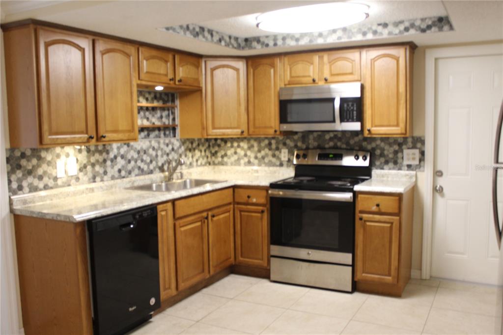 6812 Roosevelt Drive Port Richey, FL 34668 - Photo 2 of 11 a kitchen with a sink and a stove top oven
