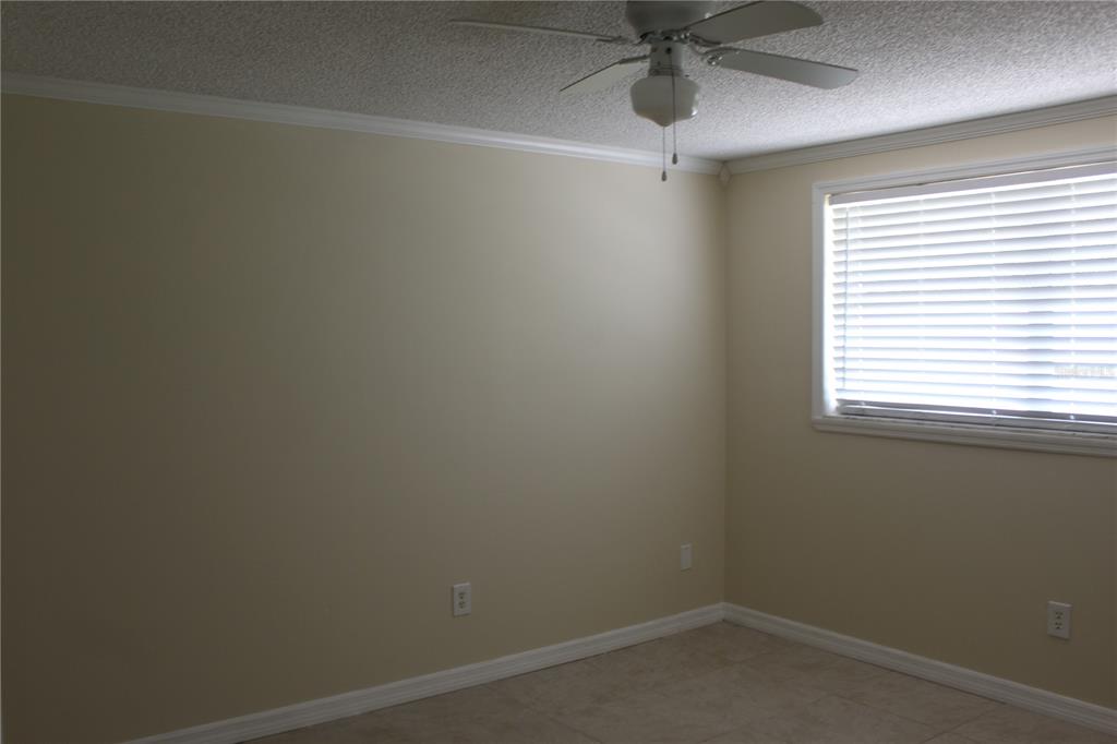 6812 Roosevelt Drive Port Richey, FL 34668 - Photo 6 of 11 an empty room with a window and a fan