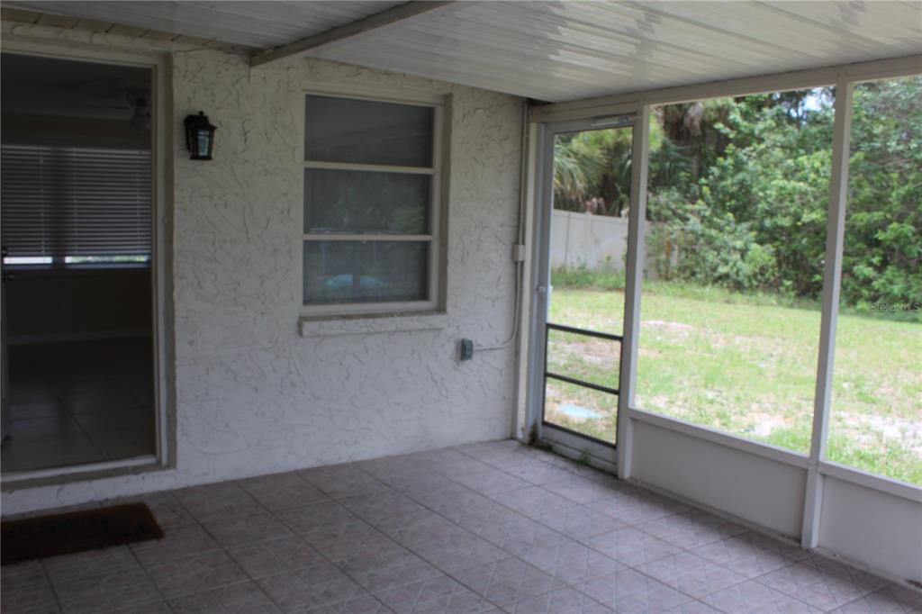 6812 Roosevelt Drive Port Richey, FL 34668 - Photo 10 of 11 an empty room with wooden floor and windows