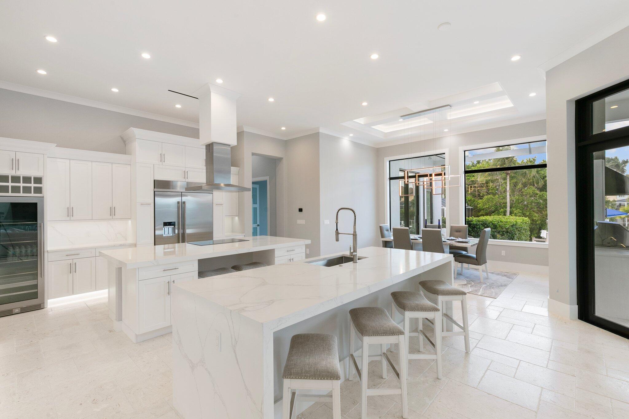 1960 San Marco Road Marco Island, FL 34145 - Photo 18 of 66 a kitchen with stainless steel appliances kitchen island granite countertop a dining table chairs and white cabinets