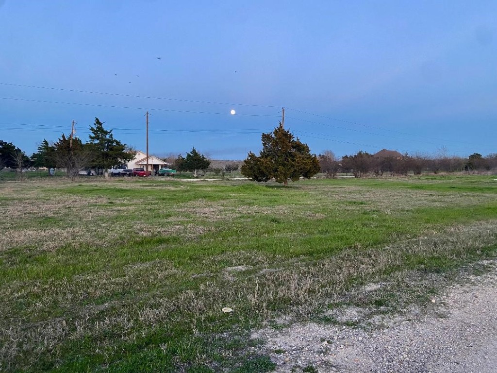 a view of a field with a house in background