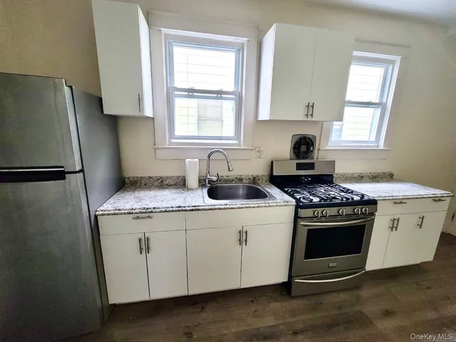 a kitchen with a stove a sink and a window