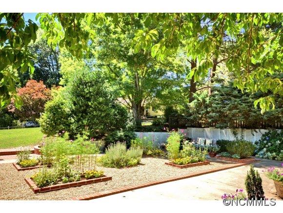 1001 Golden Road Tryon, NC 28782 - Photo 17 of 18 a view of a garden with a bench under an umbrella