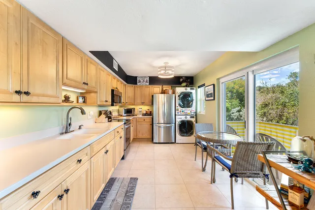 a kitchen with granite countertop a sink appliances cabinets and furniture