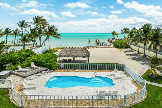 a view of a swimming pool with a patio and a yard