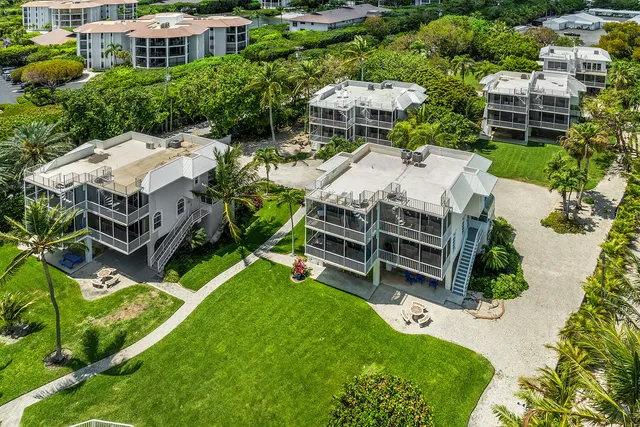 an aerial view of multiple houses with a yard