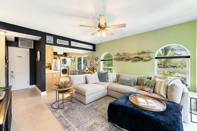 a living room with furniture a rug and a floor to ceiling window