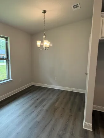 an empty room with wooden floor and window