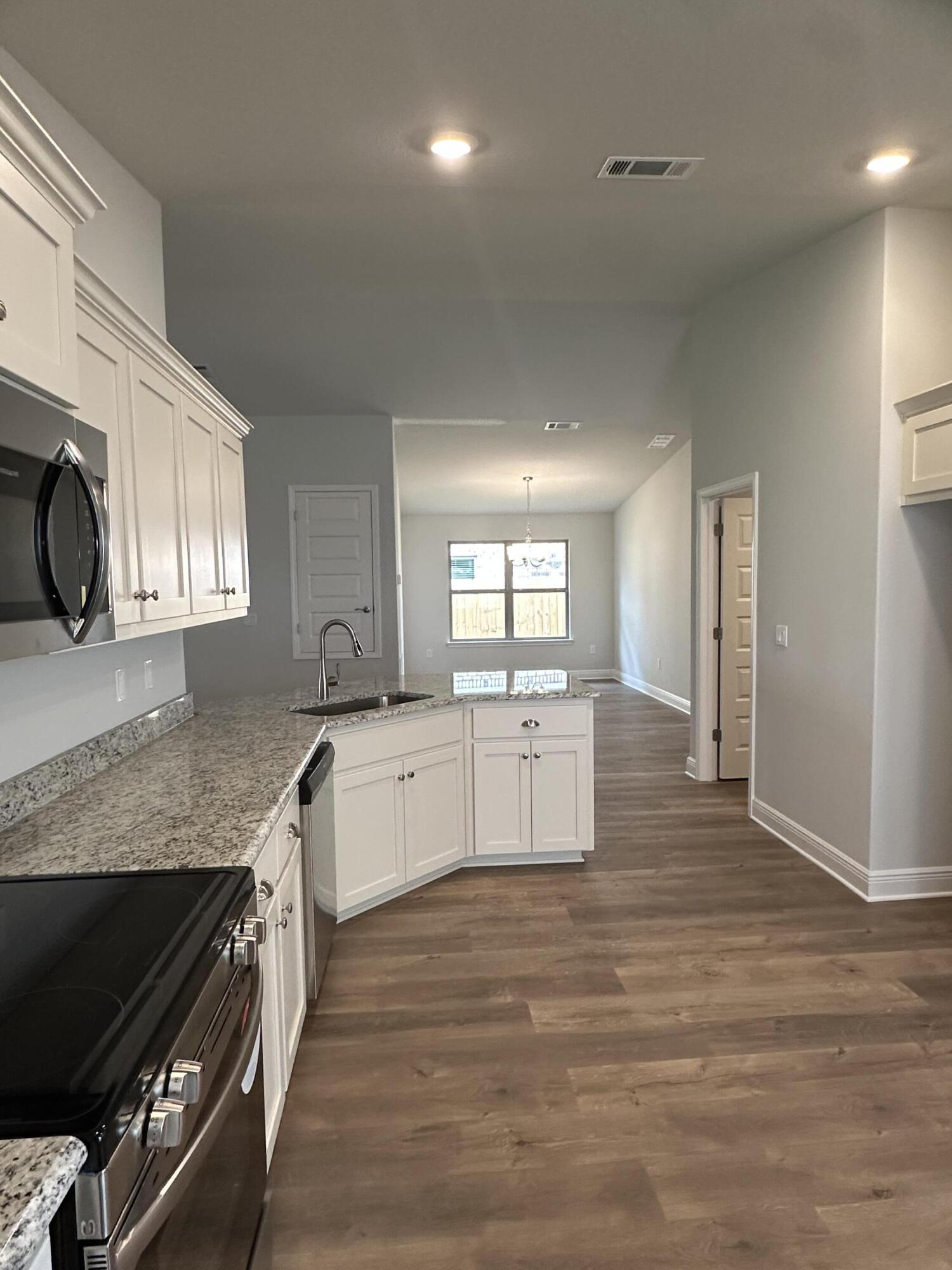 191 Ridgeway Circle Crestview, FL 32536 - Photo 12 of 26 a large kitchen with stainless steel appliances granite countertop a lot of counter space and wooden floor