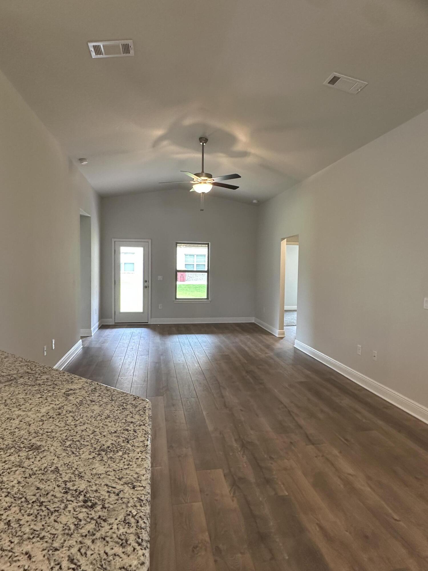 191 Ridgeway Circle Crestview, FL 32536 - Photo 13 of 26 wooden floor in an empty room with a window