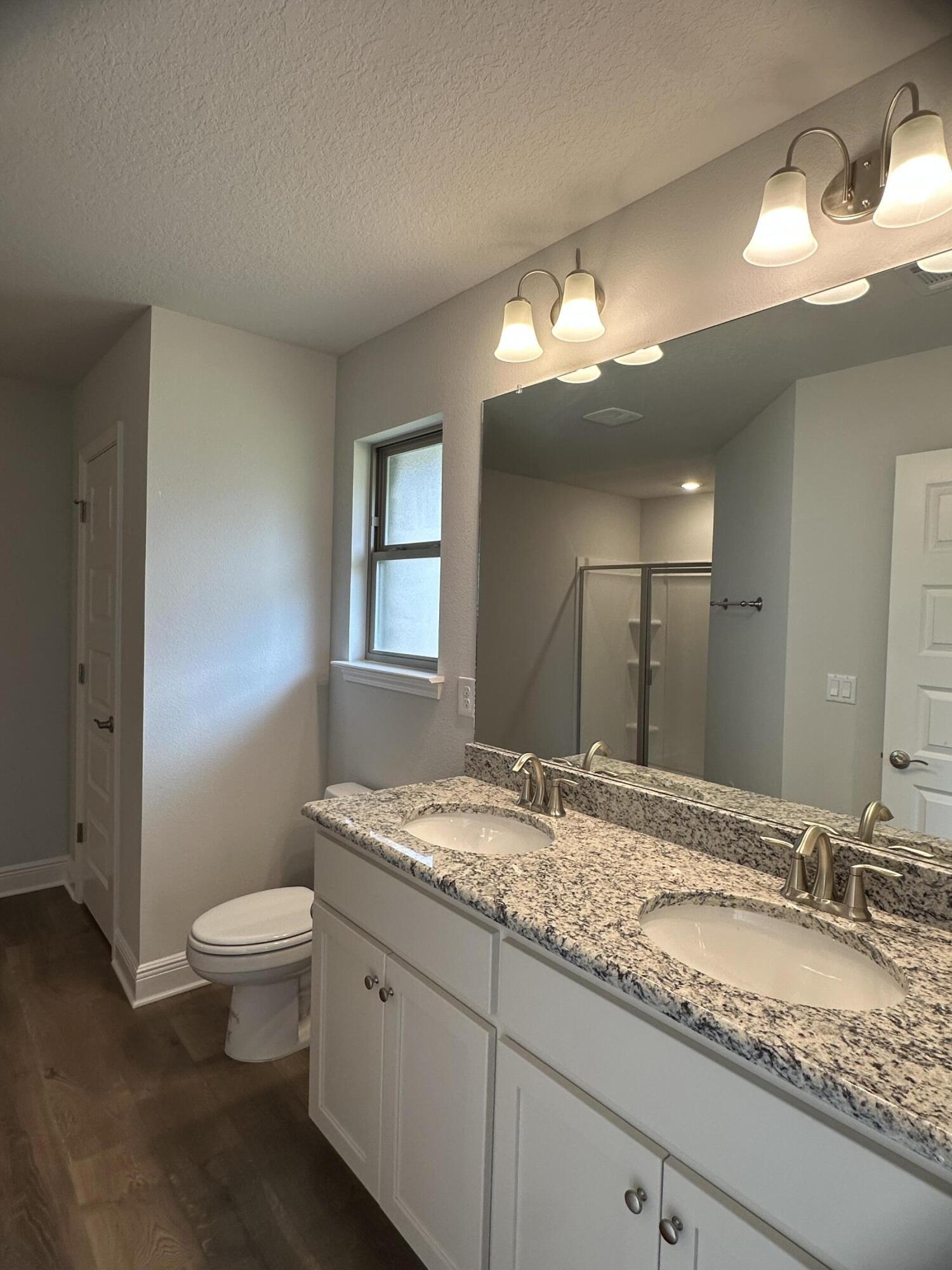 191 Ridgeway Circle Crestview, FL 32536 - Photo 18 of 26 a bathroom with a granite countertop sink a toilet and a mirror
