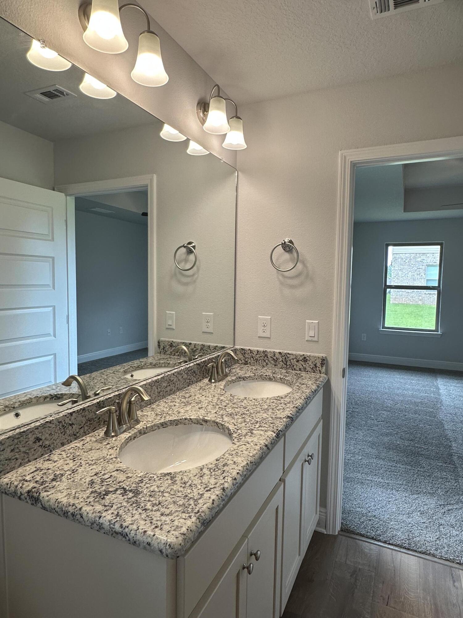 191 Ridgeway Circle Crestview, FL 32536 - Photo 21 of 26 a bathroom with a granite countertop sink and a mirror
