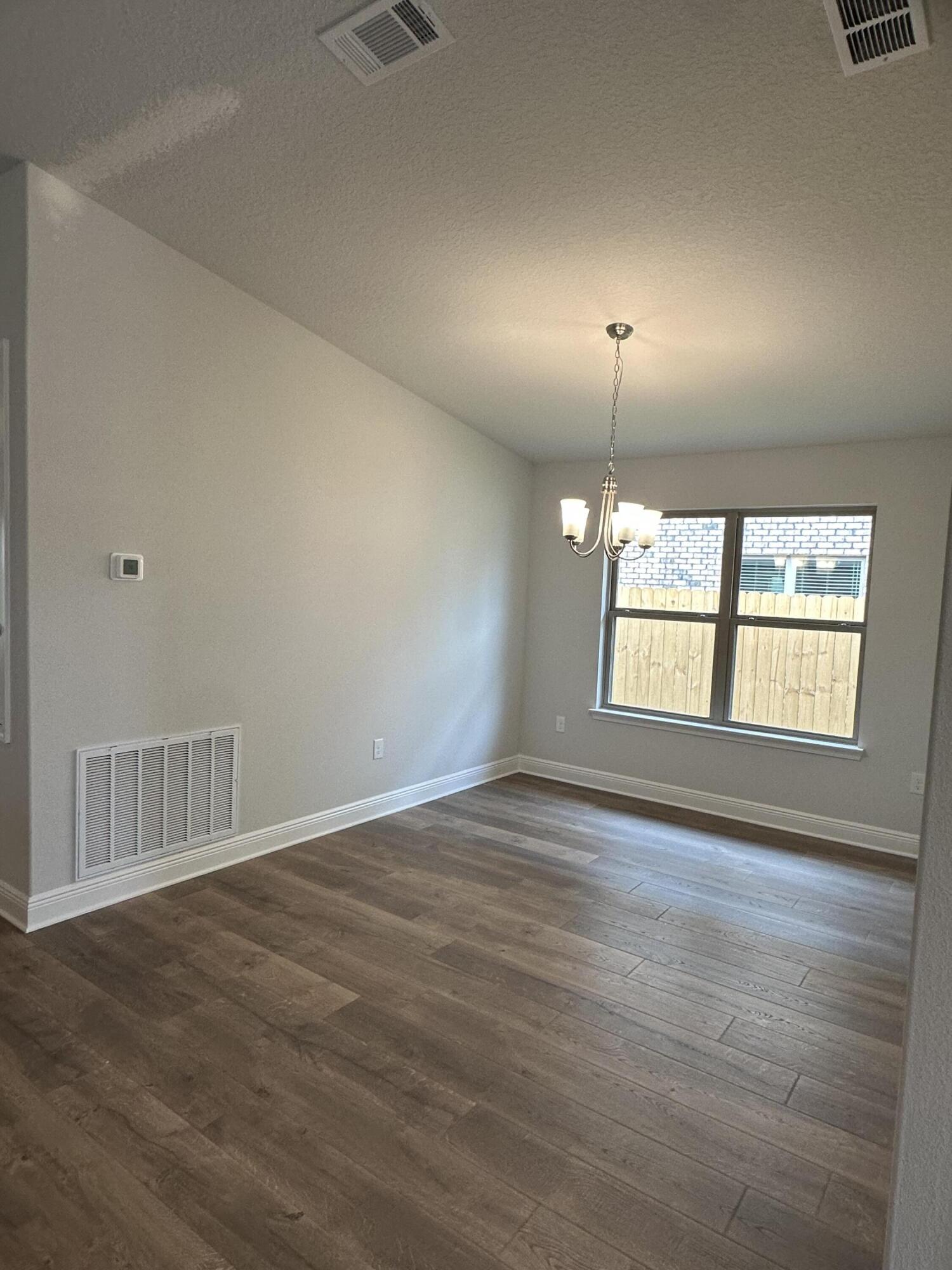 191 Ridgeway Circle Crestview, FL 32536 - Photo 5 of 26 an empty room with wooden floor and windows