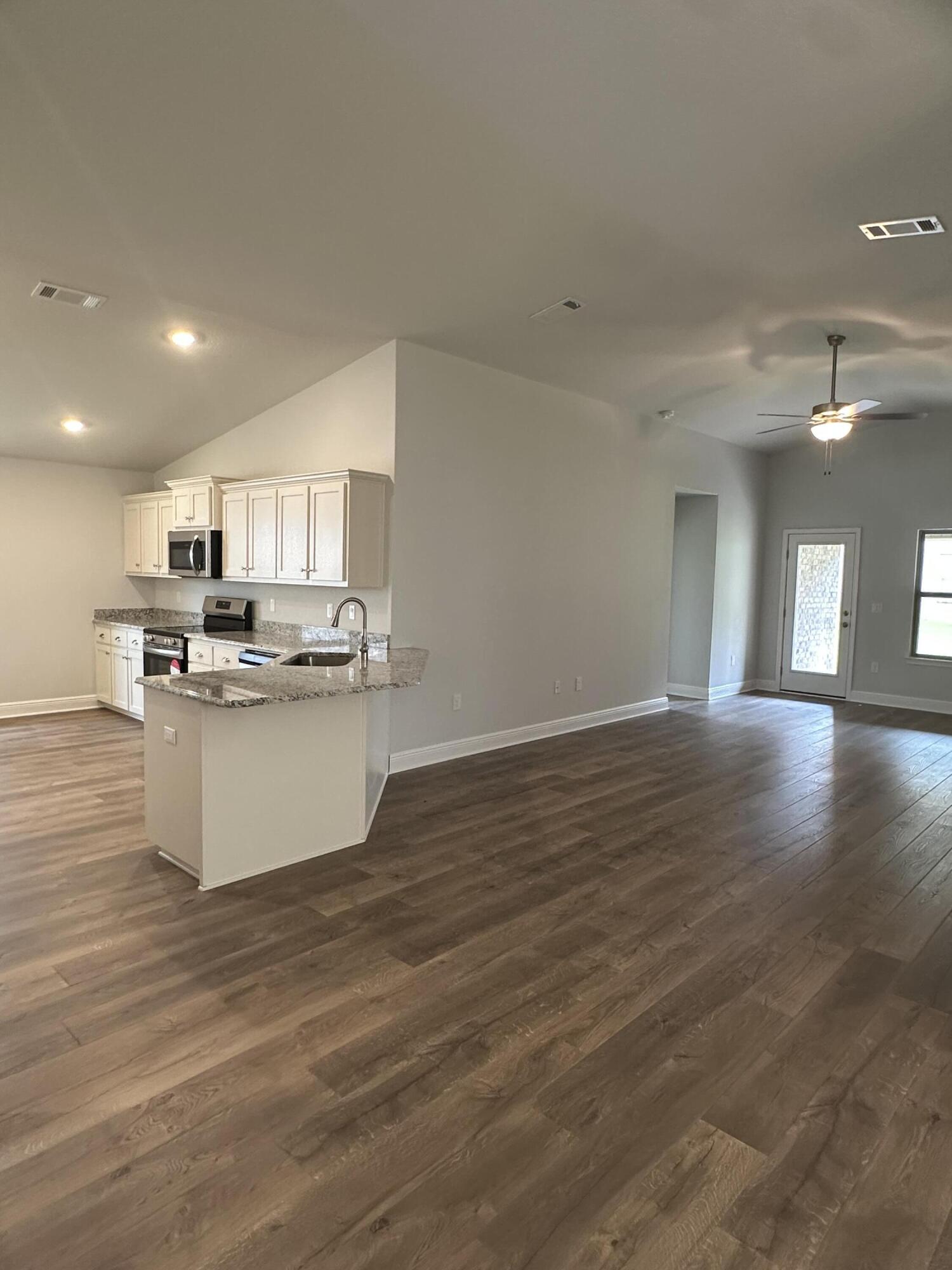 191 Ridgeway Circle Crestview, FL 32536 - Photo 6 of 26 a view of a kitchen with kitchen island a sink wooden floor and stainless steel appliances