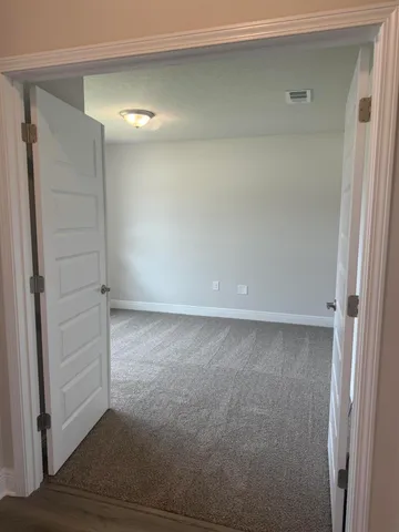 an empty room with wooden floor and window