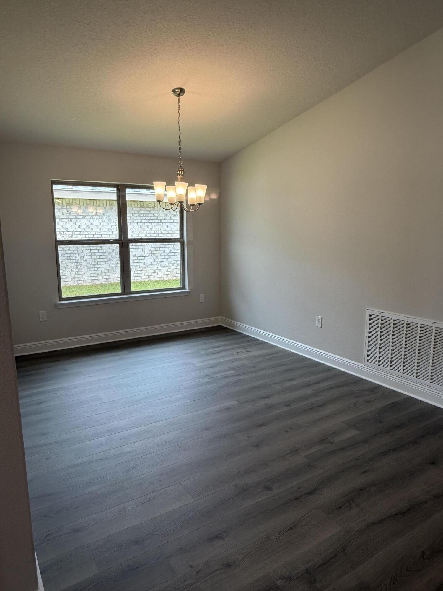 191 Ridgeway Circle Crestview, FL 32536 - Photo 7 of 21 an empty room with wooden floor and windows